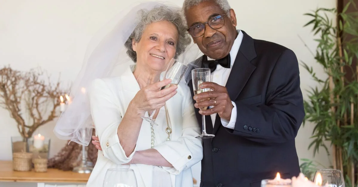 Joyeuse célébration de mariage d'un couple senior portant un toast avec du champagne à l'intérieur.