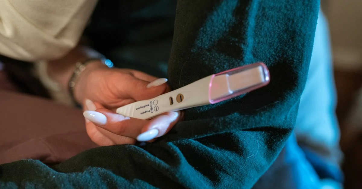 La main d'une femme tenant un test de grossesse positif, symbolisant l'espoir et de nouveaux commencements.