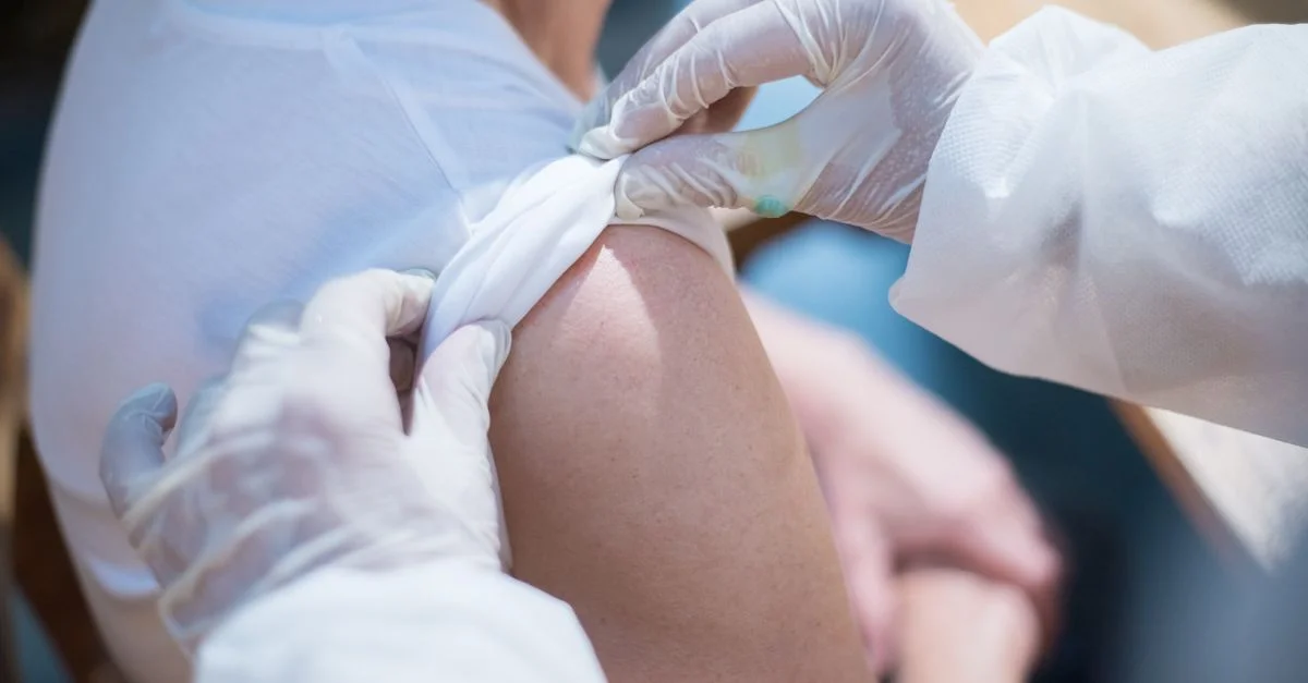 Gros plan d'un professionnel de santé administrant une vaccination à un patient au Portugal.