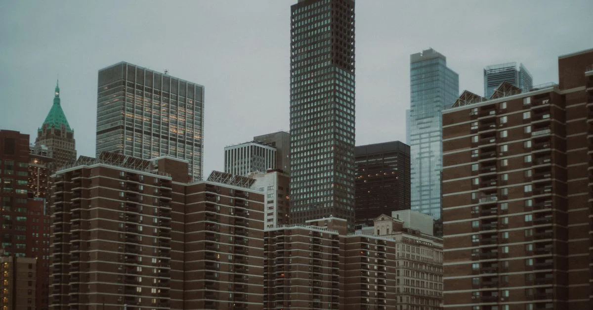 Une vue sereine de l'horizon urbain emblématique de la ville de New York avec des gratte-ciel imposants sous un ciel tamisé.