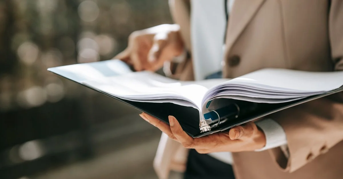 Une femme d'affaires élégante examine des documents importants en plein air. Sa tenue professionnelle et formelle renforce sa présence autoritaire.