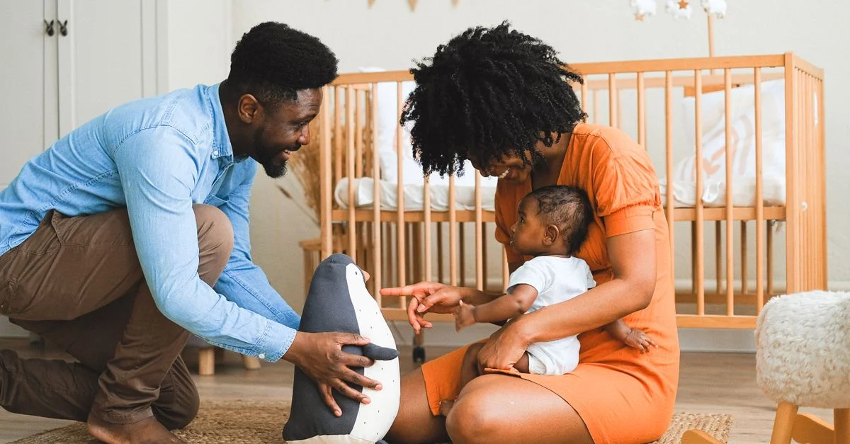 Parents joyeux partageant des moments précieux avec leur bébé dans une crèche moderne.